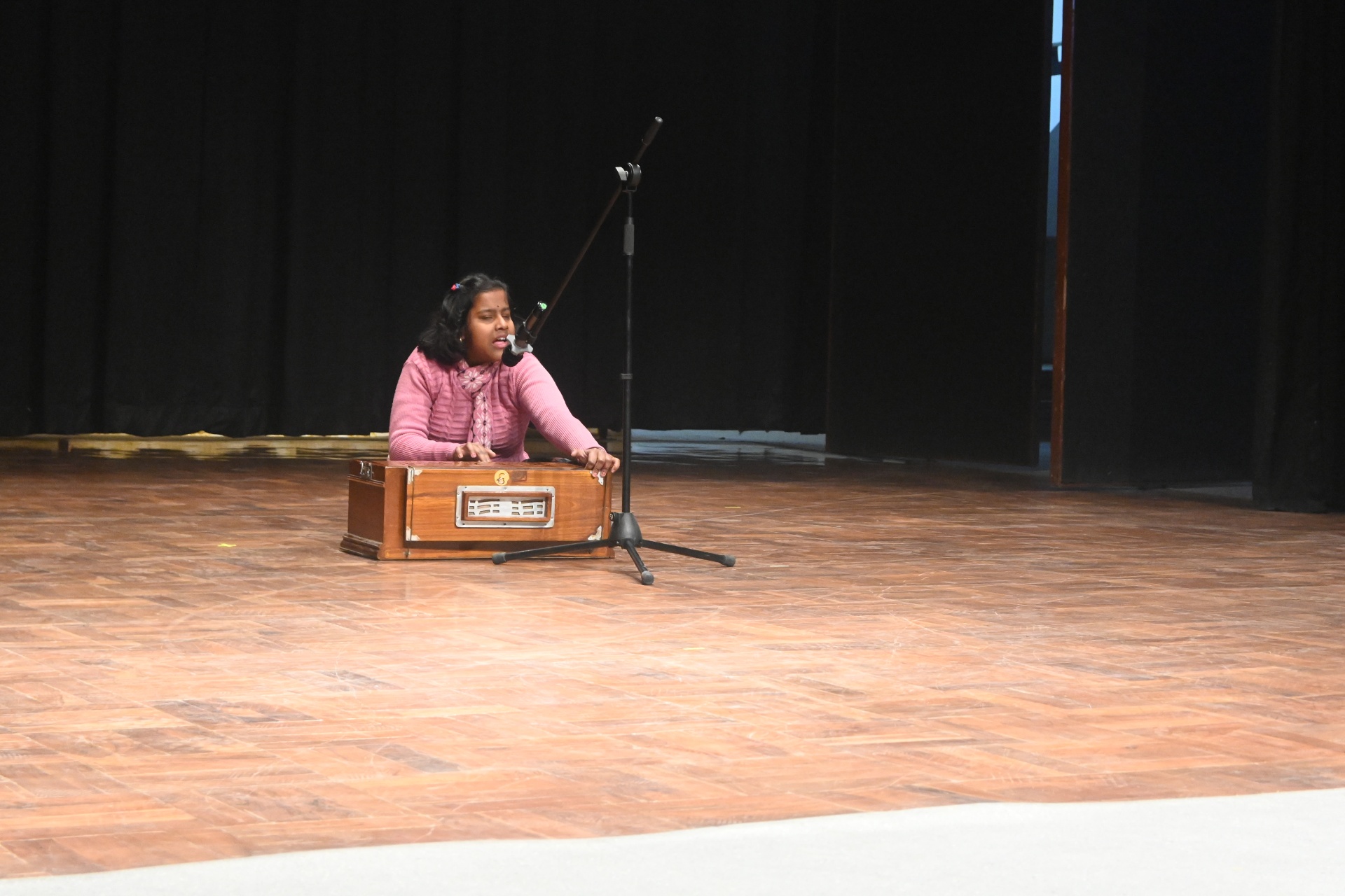 Participant with visual impairement playing the harmonium 